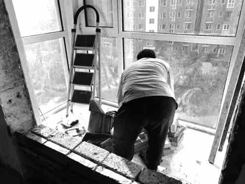 拆除违建之前，工人得先把室内的窗户重新垒建安装好
